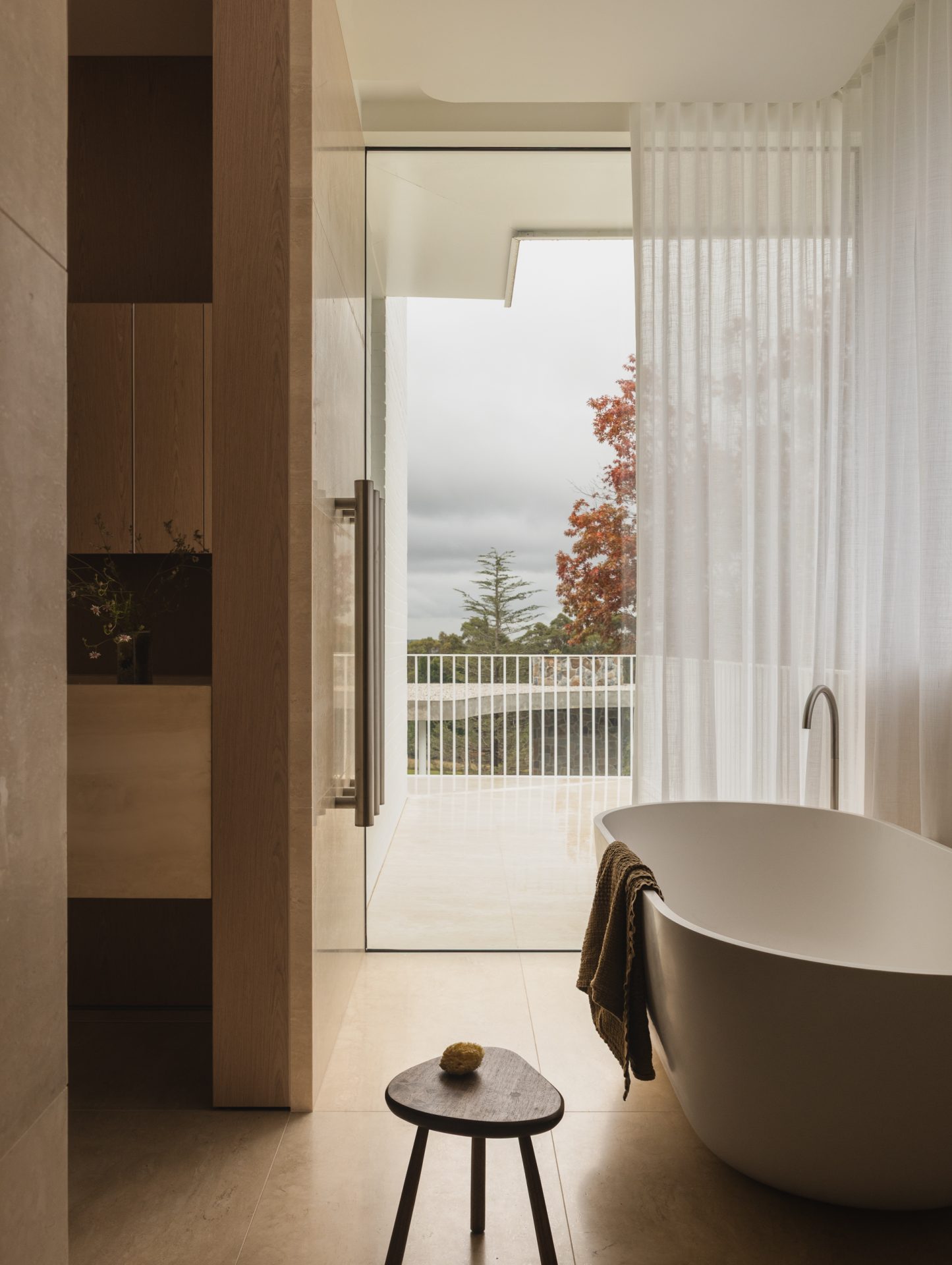 Freestanding bath beside sheer curtains at Melody House